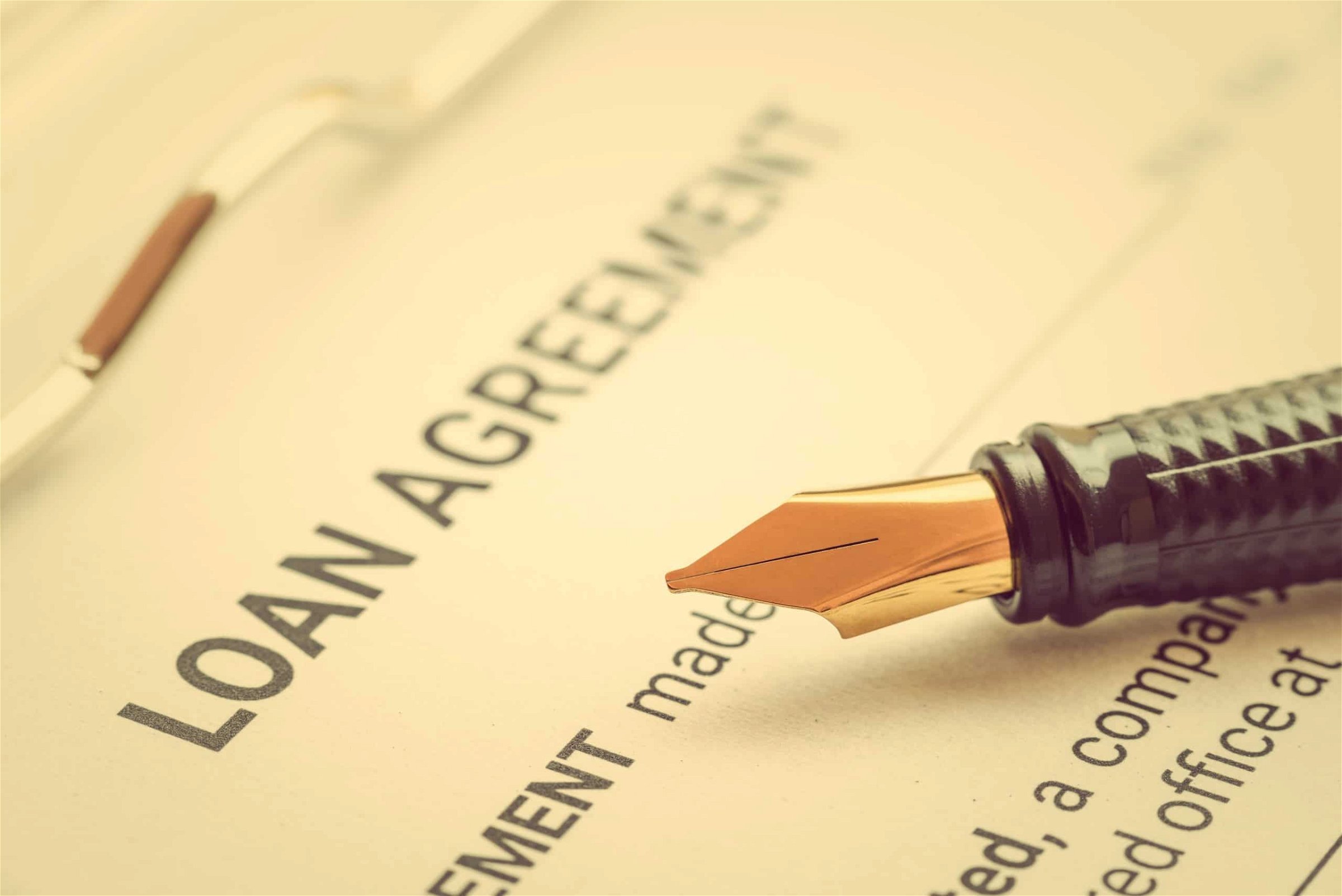 Business loan agreement or legal document concept : Fountain pen on a loan agreement paper form. Loan agreement is a contract between a borrower and a lender, a compilation of various mutual promises.