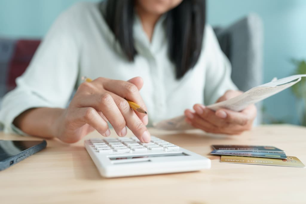 A woman calculating tax on a debt collection agencie